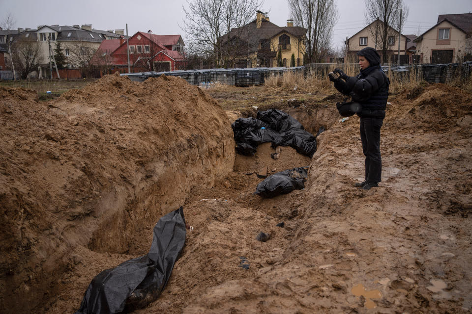 A journalist takes video of a mass grave in Bucha, on the outskirts of Kyiv, Ukraine, Sunday, April 3, 2022. Ukrainian leaders have encouraged journalists to document what is happening in the country.<span class="copyright">Rodrigo Abd—AP</span>