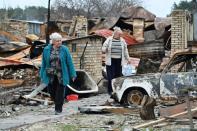 Deux habitantes parmi les débris de leurs maisons, à Mochtchoun, en Ukraine, le 20 avril 2022 (AFP/Genya SAVILOV)