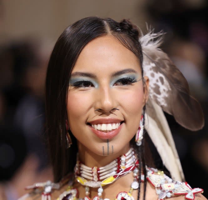 Quanah Chasinghorse smiling and wearing blue eyeshadow