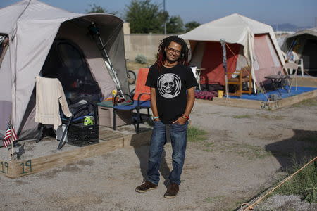 Matt Mercer, a one-time resident of Camp Hope, poses among tents in Las Cruces, New Mexico October 6, 2015. REUTERS/Shannon Stapleton