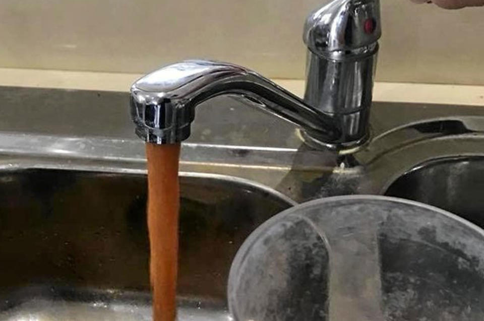 Dirty water pours from a tap in Lithgow.