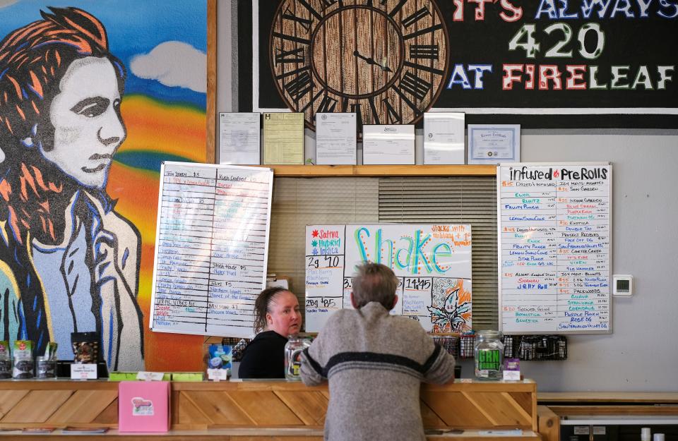 Tisha Bailey assists a customer at Fire Leaf Dispensary in Edmond.