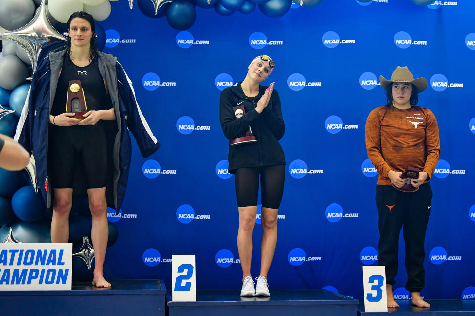 ATLANTA, GA - MARCH 17:  University of Pennsylvania swimmer Lia Thomas accepts the winning trophy for the 500 Freestyle finals as second place finisher Emma Weyant and third place finisher Erica Sullivan watch during the NCAA Swimming and Diving Championships on March 17th, 2022 at the McAuley Aquatic Center in Atlanta Georgia.  (Photo by Rich von Biberstein/Icon Sportswire via Getty Images)