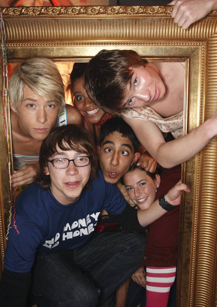 The cast of "Skins" in a promo photo as they all stand inside a massive picture frame