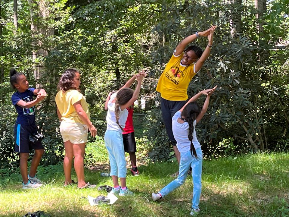 LaShanda Brown teaches yoga at a park in Brevard with scholars from the Rise & Shine after-school program.