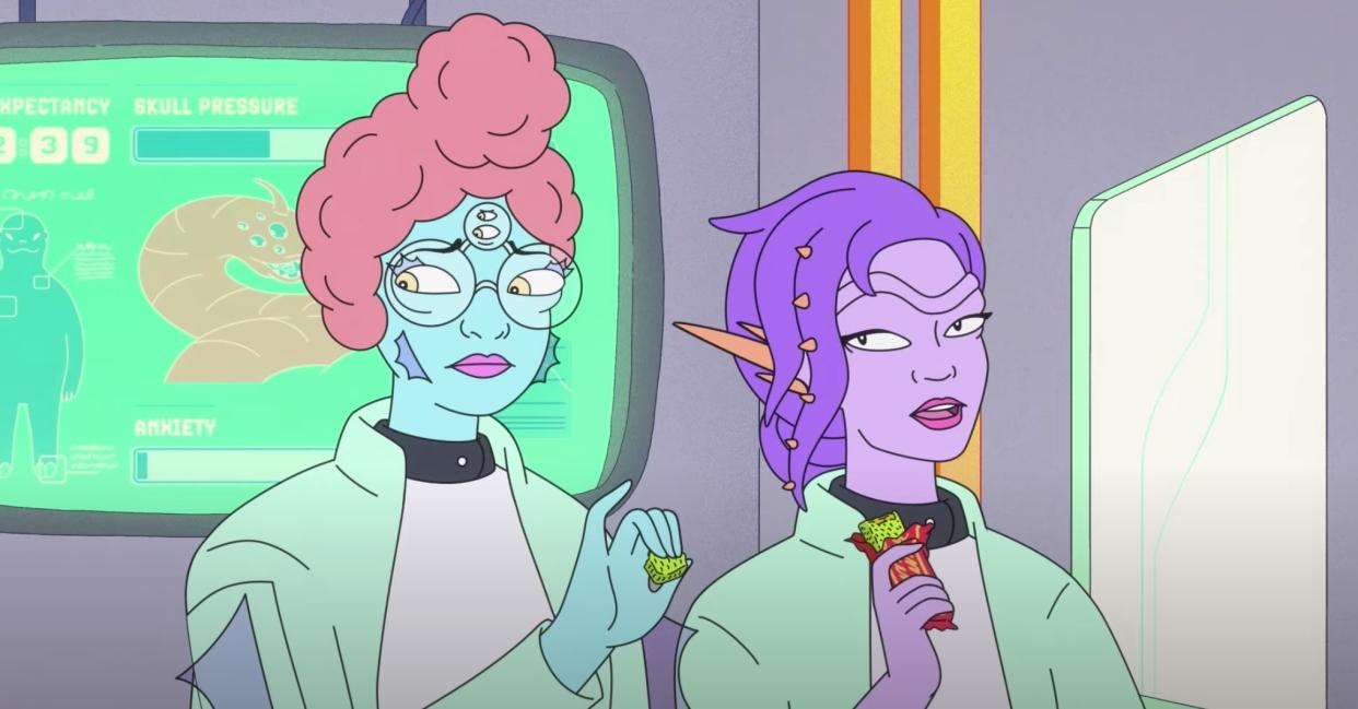  A green-skinned alien doctor with four eyes talks to a purple-skinned alien doctor, both in lab coats. 