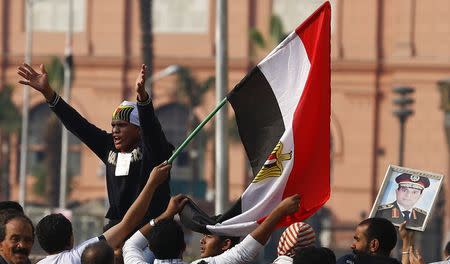 Supporters of Egypt's President Abdel Fattah al-Sisi hold up his portrait and an Egyptian flag as they shout slogans against the Muslim Brotherhood and other Islamist groups at Tahrir Square in Cairo November 28, 2014. REUTERS/Amr Abdallah Dalsh