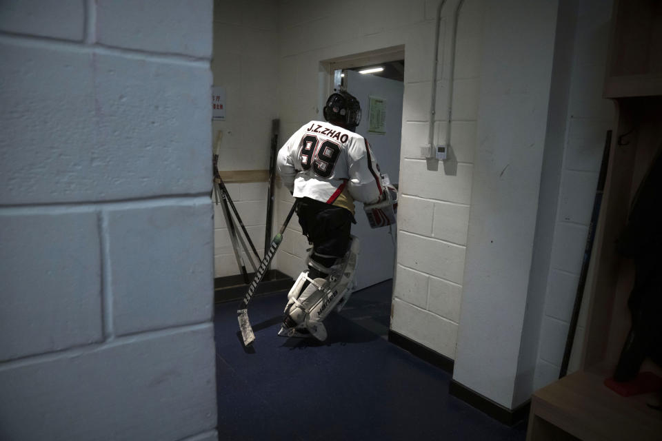 A members of the "1979" hockey club heads to the ice from the locker room before a hockey match at a rink in Beijing, Wednesday, Jan. 12, 2022. Spurred by enthusiasm after China was awarded the 2022 Winter Olympics, the members of a 1970s-era youth hockey team, now around 60 years old, have reunited decades later to once again take to the ice. (AP Photo/Mark Schiefelbein)