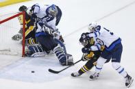 Pittsburgh Penguins' Sidney Crosby (87) gets the game-winning goal behind Winnipeg Jets goalie Connor Hellebuyck (37) with Mark Scheifele (55) defending in overtime of an NHL hockey game in Pittsburgh, Thursday, Feb. 16, 2017. The Penguins won 4-3. (AP Photo/Gene J. Puskar)