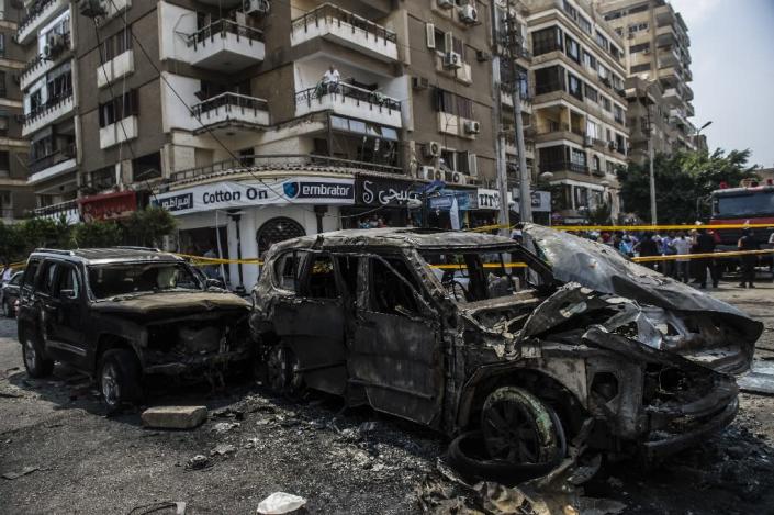 Burnt-out vehicles are seen at the site of a bomb attack that targeted the convoy of the Egyptian state prosecutor, Hisham Barakat, in Cairo on June 29, 2015 (AFP Photo/Khaled Desouki)
