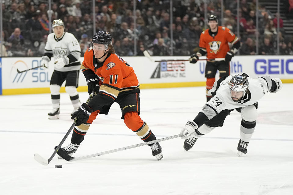 Los Angeles Kings center Phillip Danault, right, reaches in on Anaheim Ducks center Trevor Zegras during the first period of an NHL hockey game Friday, Feb. 17, 2023, in Anaheim, Calif. (AP Photo/Mark J. Terrill)