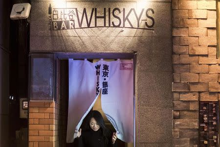 A woman leaves the Hibiya whisky bar in the Ginza district in Tokyo December 2, 2014. REUTERS/Thomas Peter