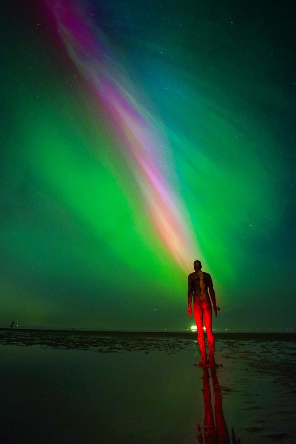 The aurora borealis glow on the horizon at Another Place by Anthony Gormley, Crosby Beach (Peter Byrne/PA Wire)