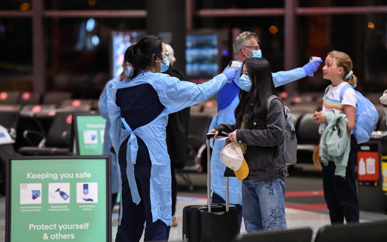 Passengers arrive from a Qantas flight that flew from Melbourne at Sydney Airport to be met by health officials taking their temperature - Getty Images AsiaPac 