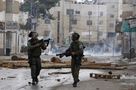 Israeli border policemen take up position during clashes with Palestinian protesters following an anti-Israel demonstration in solidarity with al-Aqsa mosque, in the West Bank city of Hebron November 21, 2014. REUTERS/Mussa Qawasma