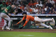 Houston Astros' Jeremy Pena scores next to Oakland Athletics catcher Sean Murphy on a sacrifice fly by Mauricio Dubon during the eighth inning of a baseball game Friday, Aug. 12, 2022, in Houston. (AP Photo/Kevin M. Cox)