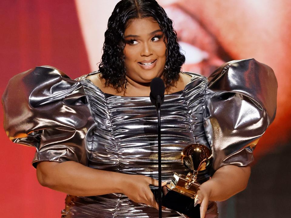 Lizzo on stage at the 2023 Grammys with her award for record of the year.