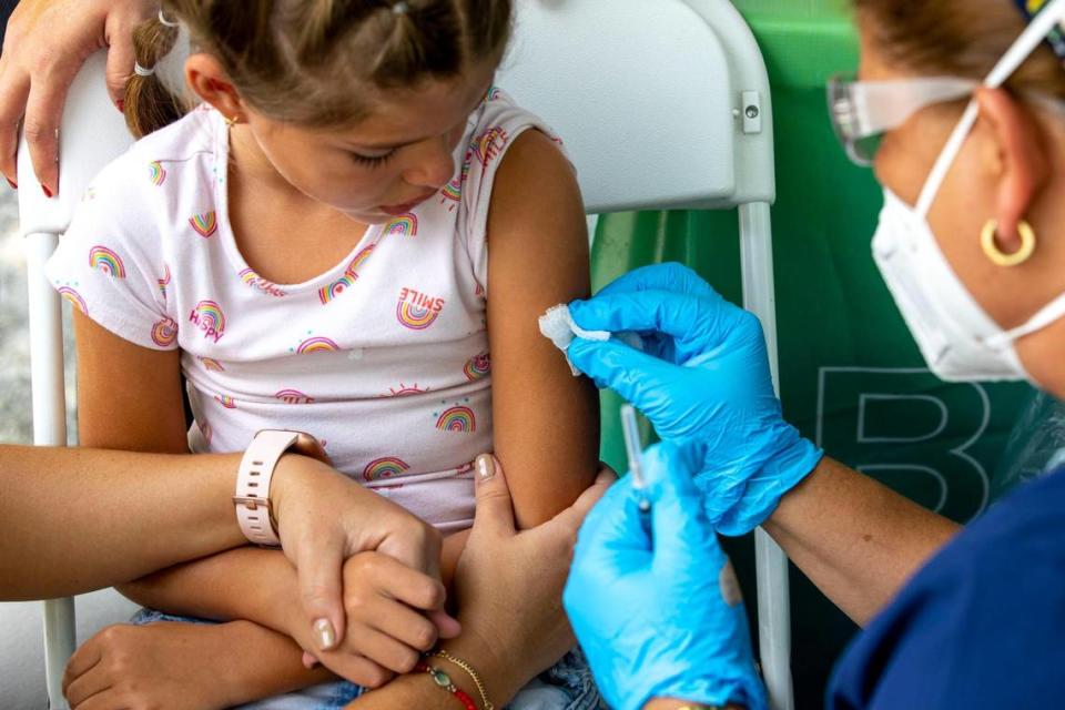Mia Díaz, de siete años, se prepara para recibir la vacuna contra el COVID-19 en la Unidad Móvil de Salud de Nomi Health dentro de Tropical Park en Miami, la Florida, el sábado 25 de junio de 2022. El sábado, el Condado Miami-Dade comenzó a ofrecerle las vacunas a los niños menores de cinco años, el último grupo autorizado para recibir las vacunas.