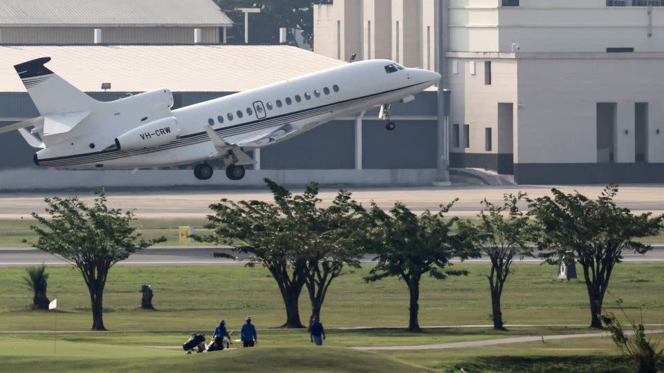 Golfers walk the fairways as a jet takes off. - Jack Taylor/AFP/Getty Images