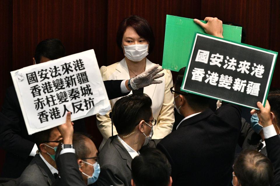 Hong Kong pro-democracy lawmakers holding up placards are blocked by security as they protest during a House Committee meeting, chaired by pro-Beijing lawmaker Starry Lee (top C-in white jacket), concerning the second reading of a national anthem bill, at the Legislative Council in Hong Kong on May 22, 2020. - A proposal to enact new Hong Kong security legislation was submitted to China's rubber-stamp on May 22, state media said, a move expected to fan fresh protests in the semi-autonomous financial hub. (Photo by Anthony WALLACE / AFP) (Photo by ANTHONY WALLACE/AFP via Getty Images)