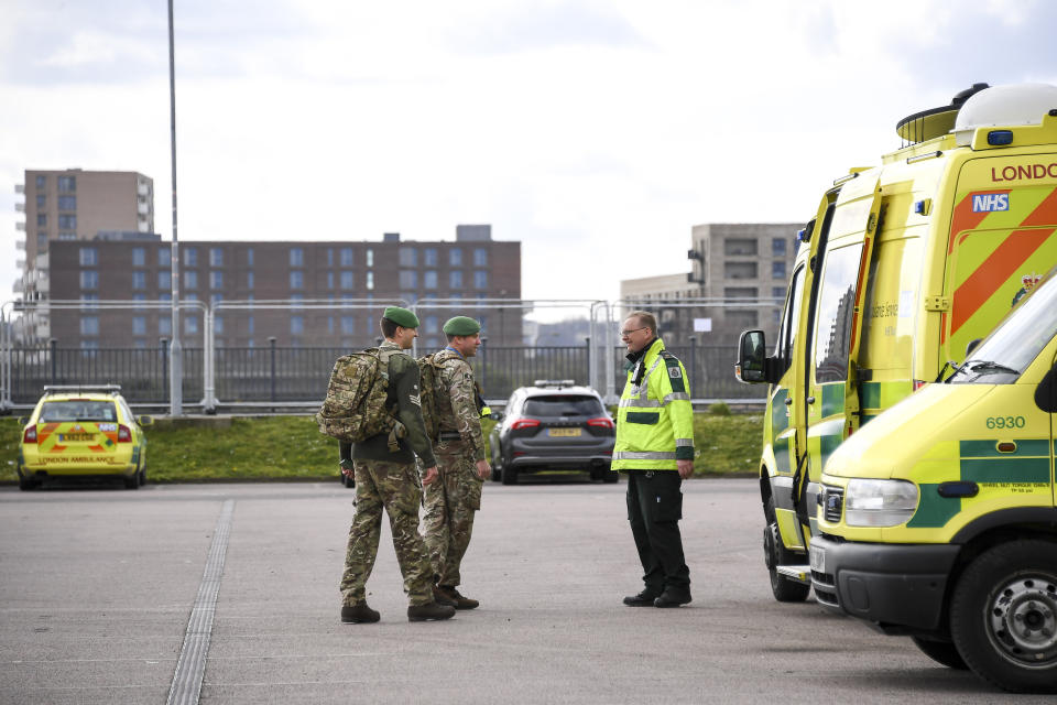 Military personnel and ambulance staff at the ExCel Center in London, Thursday, April 2, 2020, that is being turned into a 4000 bed temporary hospital know as NHS Nightingale to help deal with some of the coronavirus outbreak victims in London. The new coronavirus causes mild or moderate symptoms for most people, but for some, especially older adults and people with existing health problems, it can cause more severe illness or death. (AP Photo/Alberto Pezzali)