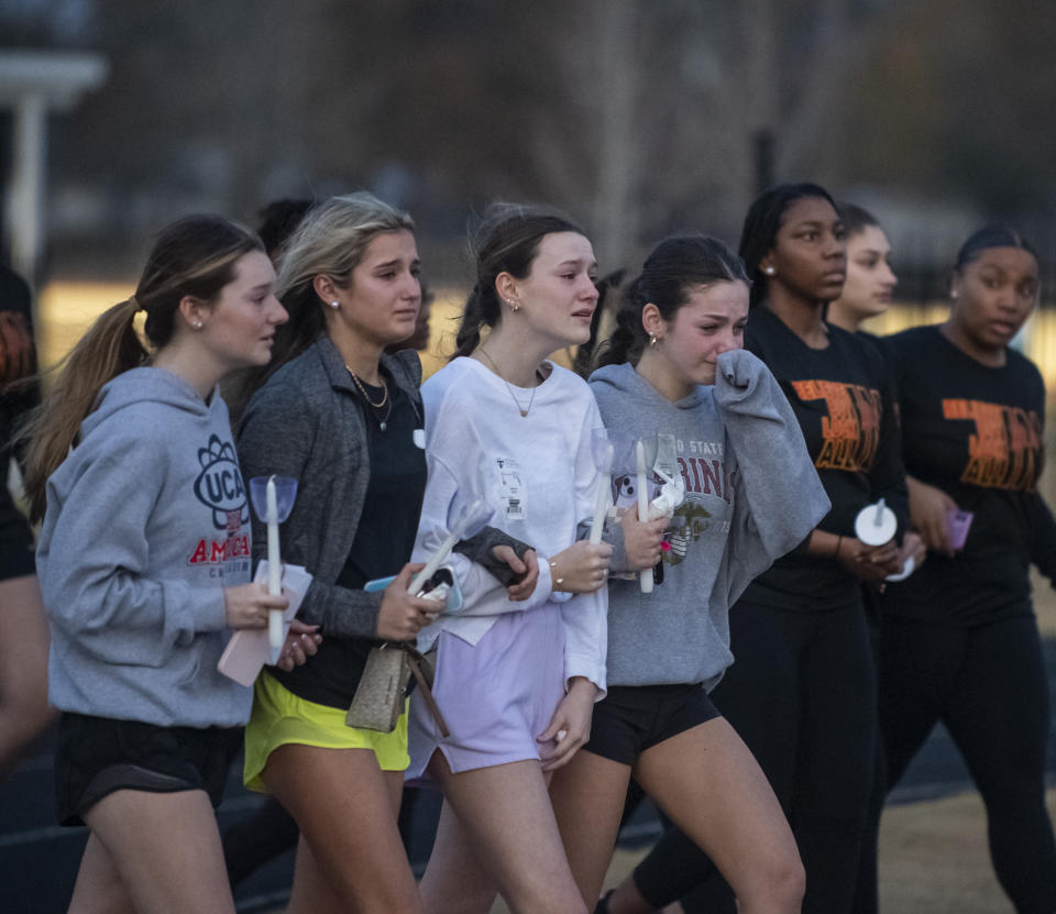 Students walk to the Brusly High School football field for the candlelight vigil for Maggie Dunn and Caroline Gill on Monday, Jan. 2, 2023 in Brusly, La. A police officer has been charged over his role in the death of two teenagers during the high-speed pursuit of a home-invasion suspect in Louisiana. (Michael Johnson/The Advocate via AP)