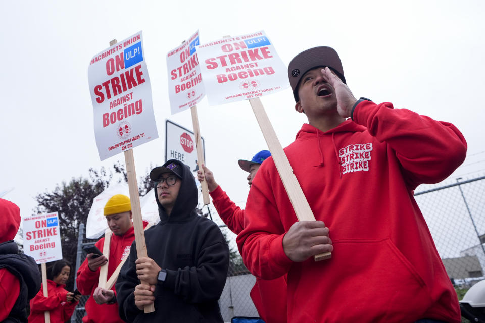 Boeing wing mechanic lead Lee Lara, who has worked for the company for 16 years, yells in response to honks from passing drivers as workers wave picket signs while striking after union members voted to reject a contract offer, Sunday, Sept. 15, 2024, near the company's factory in Everett, Wash. (AP Photo/Lindsey Wasson)