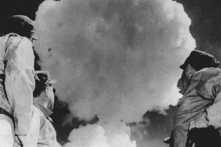 Soldiers watch the mushroom cloud from an atomic explosion in 1952 at Yucca Flat, in Nevada. Yucca Flat was used as a test site. In all, nearly 1,000 nuclear tests were conducted there by the U.S. government, most of them underground.