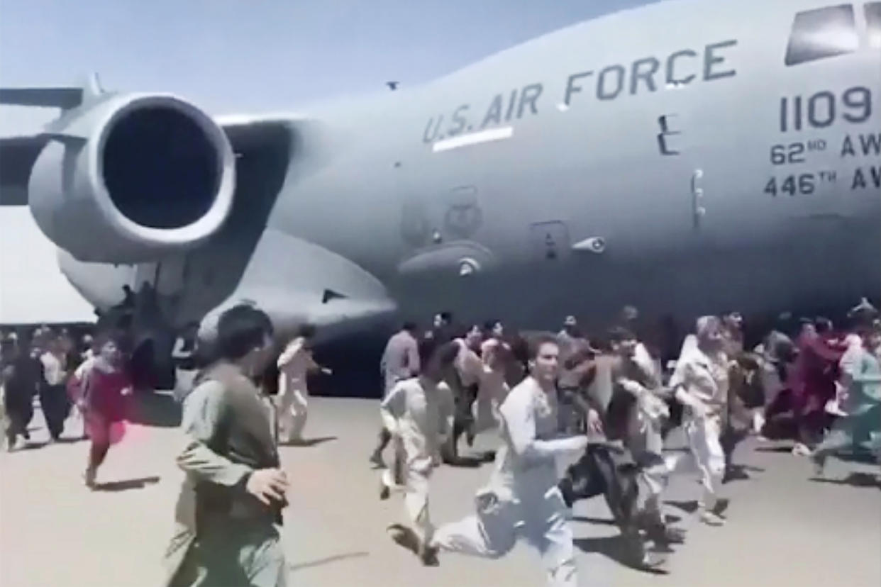 Afghans run alongside a U.S. Air Force C-17 transport plane as it moves down a runway of the international airport in Kabul on Aug. 16. 2021.  (AP file)