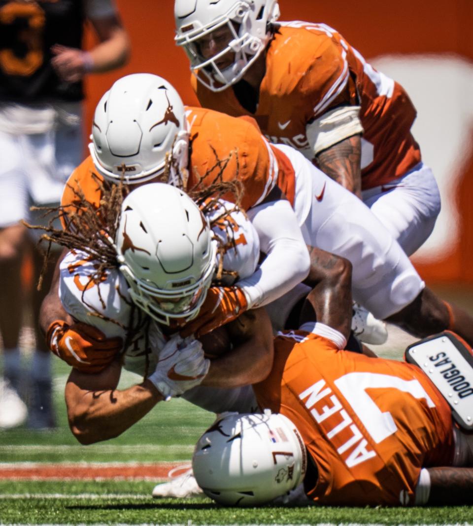 Wide receiver Jordan Whittington is taken down after making a catch during Saturday's Orange-White game at Royal-Memorial Stadium. It put the wraps on Texas' spring football workouts.
