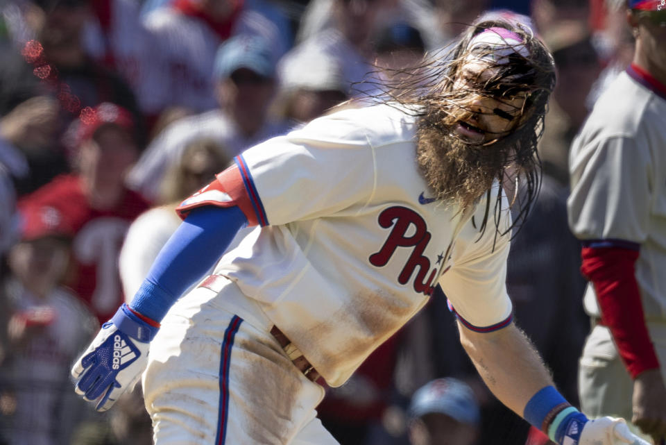 Philadelphia Phillies' Brandon Marsh is caught between third base and home on a rundown during the fourth inning of a baseball game against the Cincinnati Reds, Sunday, April 9, 2023, in Philadelphia. Marsh was tagged out on the play. (AP Photo/Laurence Kesterson)