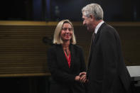 European Union Foreign Policy chief Federica Mogherini, left, shakes hands with UN High Commissioner for Refugees Filipo Grandi at the end of a joint news conference at the EU headquarters in Brussels, Tuesday, Oct. 29, 2019. The European Union says a "solidarity conference" has raised around 120 million euros ($133 million) for Venezuelans fleeing their crisis-wracked country and to help countries who are hosting them. (AP Photo/Francisco Seco)