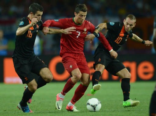 Portuguese forward Cristiano Ronaldo (C) vies with Dutch midfielder Wesley Sneijder (R) and Dutch forward Robin van Persie during the Euro 2012 football championships match Portugal vs. Netherlands, on June 17, 2012 at the Metalist stadium in Kharkiv. Portugal won 2 to 1