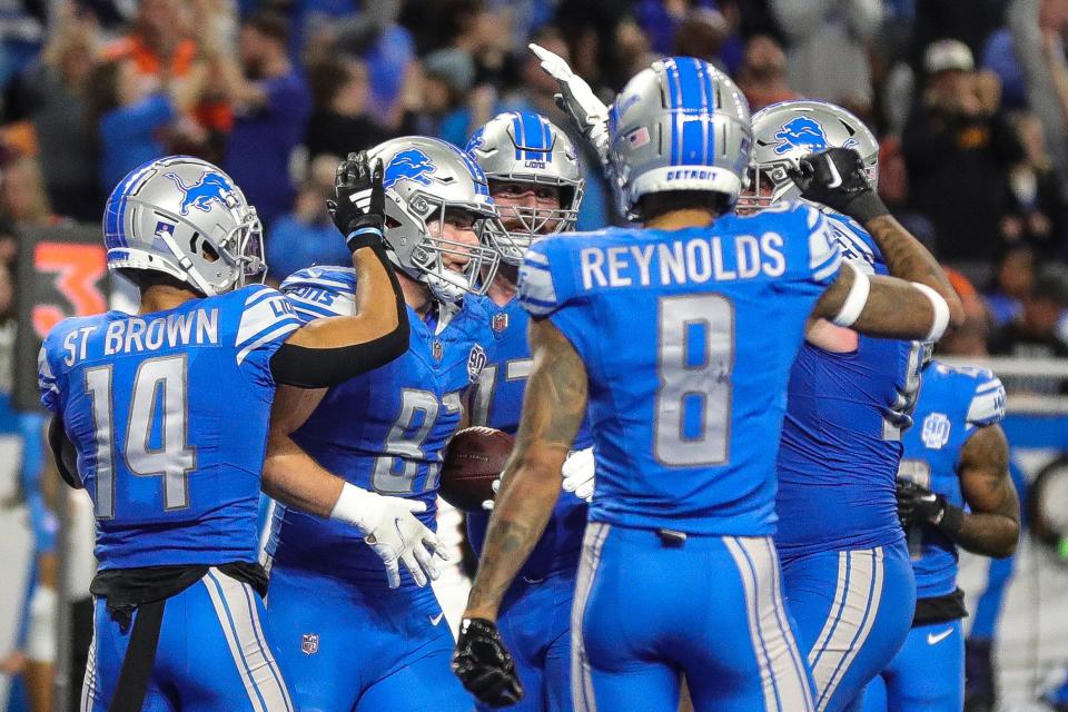 Detroit Lions players celebrate a touchdown against the Denver Broncos scored by tight end Sam LaPorta (87) during the second half at Ford Field in Detroit on Saturday, Dec. 16, 2023.