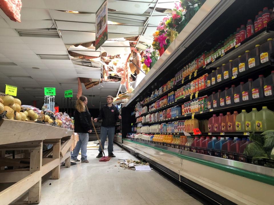 The IGA in Cairo, Ga. was badly damaged by a tornado last night. Gabe Lewis, pictured with Jessica Johnson cleaning the damage, was the manager on duty during the storm and took about 20 people who were in the store to the back room when he received a warning on his phone.