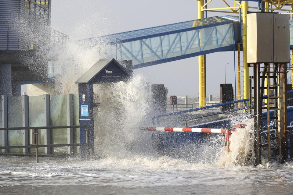 The North Sea crashes into the Dagebull ferry terminal, in Dagebull, Germany, Sunday Jan. 30, 2022, during stormy weather. (Bodo Marks/dpa via AP)