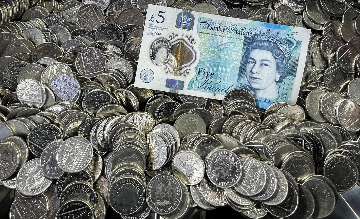 LYME REGIS, UNITED KINGDOM - MARCH 20: A Sterling British Five Pound GBP bank note lies on top of 10p coins that are in an amusement arcade slot machine, on March 20, 2022 in Lyme Regis, England. The UK is currently facing a cost of living crisis, as inflation hits a near-30-year high and rising energy bills will squeeze household incomes still further. To add to the misery, many UK households face a further rises in home energy prices when the energy price cap is likely to be raised in April.  (Photo by Matt Cardy/Getty Images)