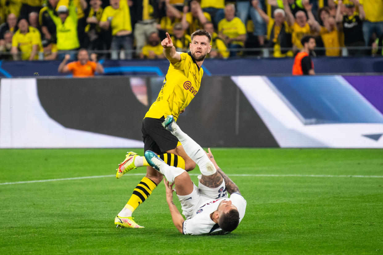 DORTMUND, GERMANY - MAY 01: Niclas Fullkrug of Dortmund celebrates after scoring his team's first goal while Lucas Hernandez (L) and Gianluigi Donnarumma (R) are laying on the ground during the UEFA Champions League semi-final first leg match between Borussia Dortmund and Paris Saint-Germain at Signal Iduna Park on May 1, 2024 in Dortmund, Germany. (Photo by Hesham Elsherif/Anadolu via Getty Images)