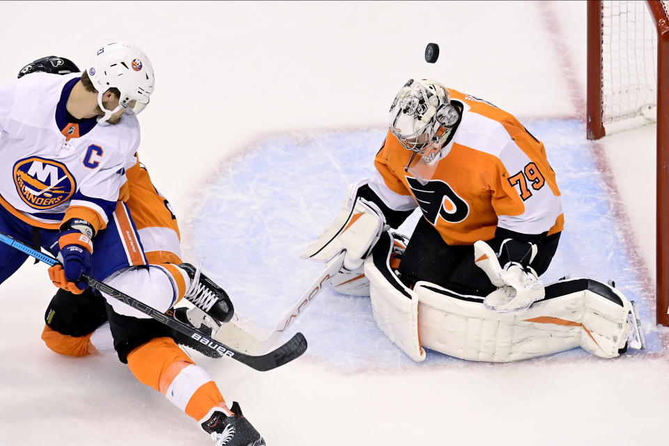 Philadelphia Flyers goaltender Carter Hart, right, makes a save as New York Islanders left wing Anders Lee, left, during the first period of an NHL Stanley Cup Eastern Conference playoff hockey game in Toronto, Ontario, Tuesday, Sept. 1, 2020. (Frank Gunn/The Canadian Press via AP)
