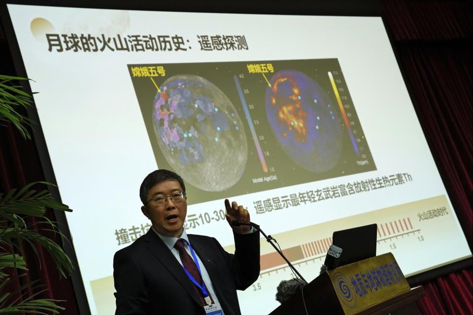 Li Xianhua speaks near a screen showing the volcano activities on the moon during a press briefing on Chang'e 5 Moon Mission, at the Chinese Academy Science in Beijing, Tuesday, Oct. 19, 2021. Moon rocks that a Chinese robotic space craft brought back to Earth last year have provided new insights into ancient lunar volcanic activity, a researcher said Tuesday. Li said an analysis of the samples revealed new information about the moon's chemical composition and the way heat affected its development. (AP Photo/Andy Wong)