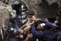 Rescue workers carry a girl who was rescued from the rubble at the site of a collapsed residential building in Mumbai September 27, 2013. The five-storey apartment block collapsed on Friday in the Indian financial centre of Mumbai, killing at least four people and trapping scores in the latest accident to underscore shoddy building standards in Asia's third-largest economy. REUTERS/Stringer