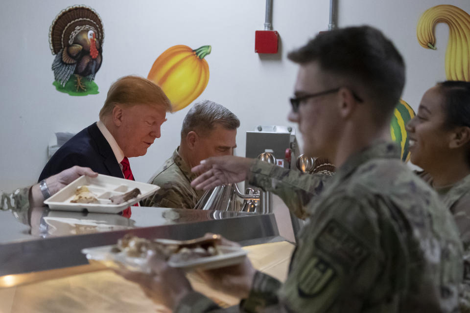 President Donald Trump, left, serves dinner accompanied by Joint Chiefs Chairman Gen. Mark Milley, center, during a surprise Thanksgiving Day visit to the troops, Thursday, Nov. 28, 2019, at Bagram Air Field, Afghanistan. (AP Photo/Alex Brandon)