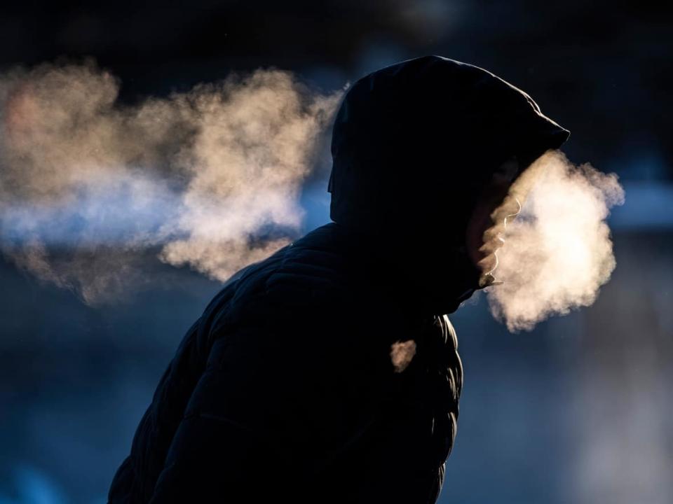 A person exhales as they make their way along the Rideau Canal Skateway in Ottawa on Saturday, Jan. 15, 2022. Environment Canada has more extreme cold warnings for most of the region. (Justin Tang/The Canadian Press - image credit)