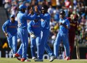 India's Ravindra Jadeja (C) and Rohit Sharma (L) celebrate the dismissal of West Indies batsman Andre Russell during their Cricket World Cup match in Perth, March 6, 2015. REUTERS/David Gray