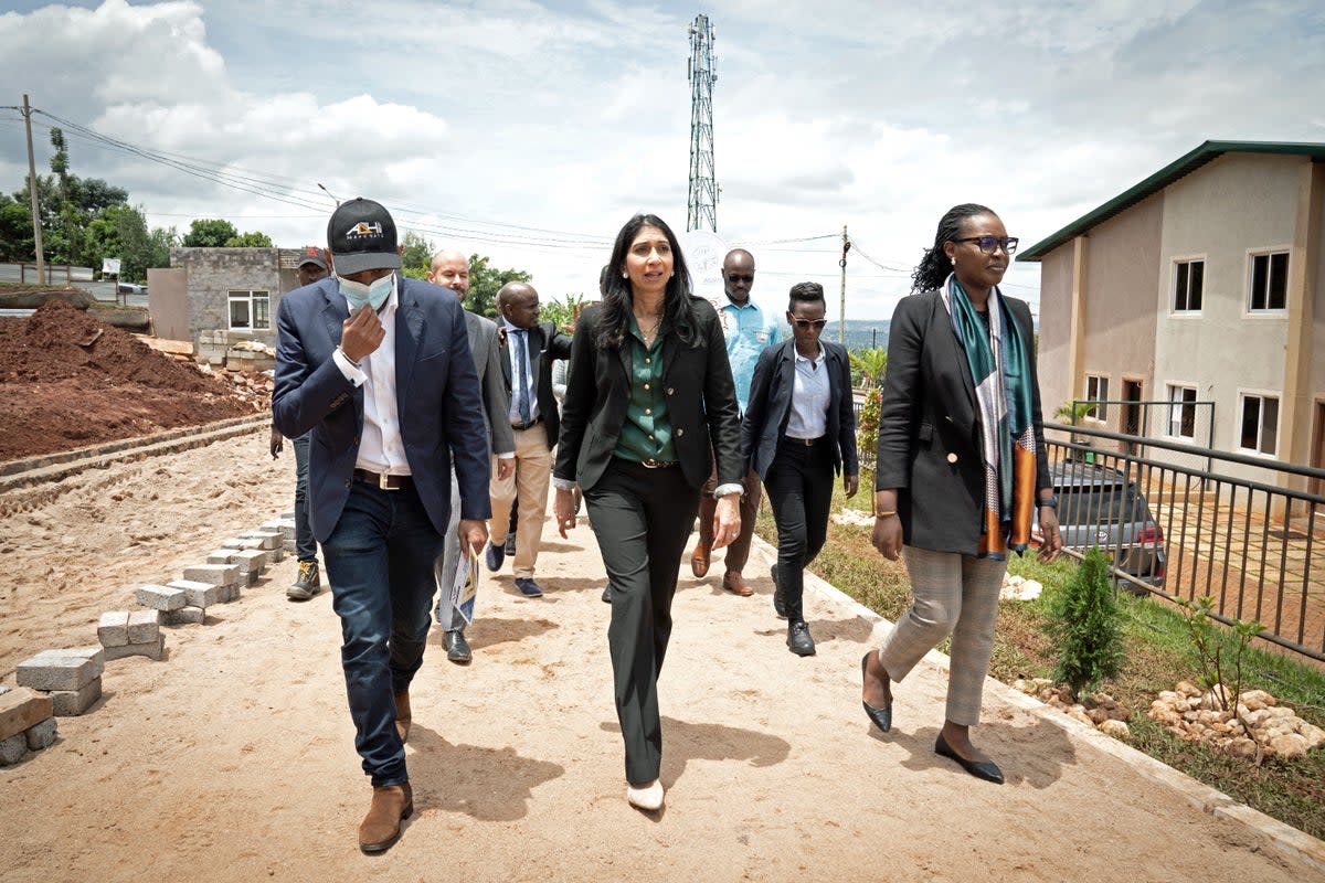 Suella Braverman, centre, tours a building site on the outskirts of Kigali (PA Wire)