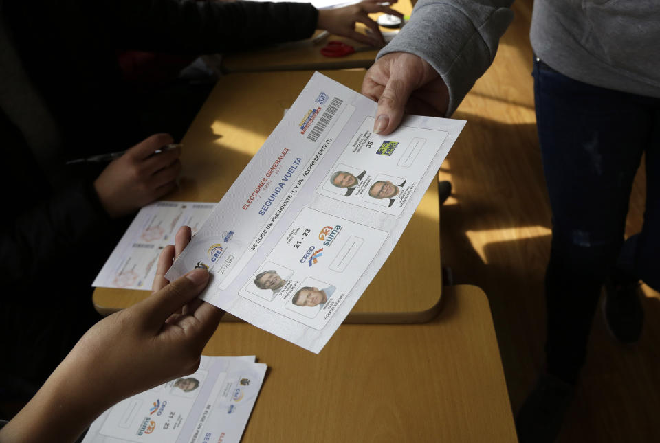 Una mujer recibe su plantilla para votar durante la segunda ronda de elecciones en Quito, Ecuador, el domingo 2 de abril de 2017. Las encuestas arrojaban una votación cerrada entre el candidato oficialista, Lenín Moreno, y el exbanquero de derecha Guillermo Lasso. (AP Foto/Dolores Ochoa)