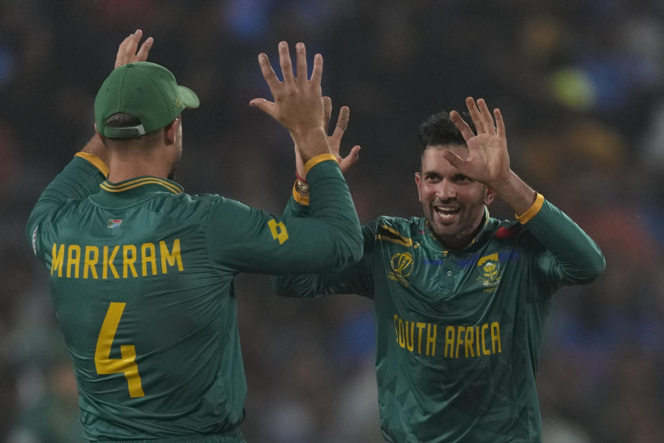 South Africa's Keshav Maharaj, left, celebrates the wicket of New Zealand's Jimmy Neesham with South Africa's Aiden Markram during the ICC Men's Cricket World Cup match between New Zealand and South Africa in Pune, India, Wednesday, Nov.1, 2023. (AP Photo/Manish Swarup)