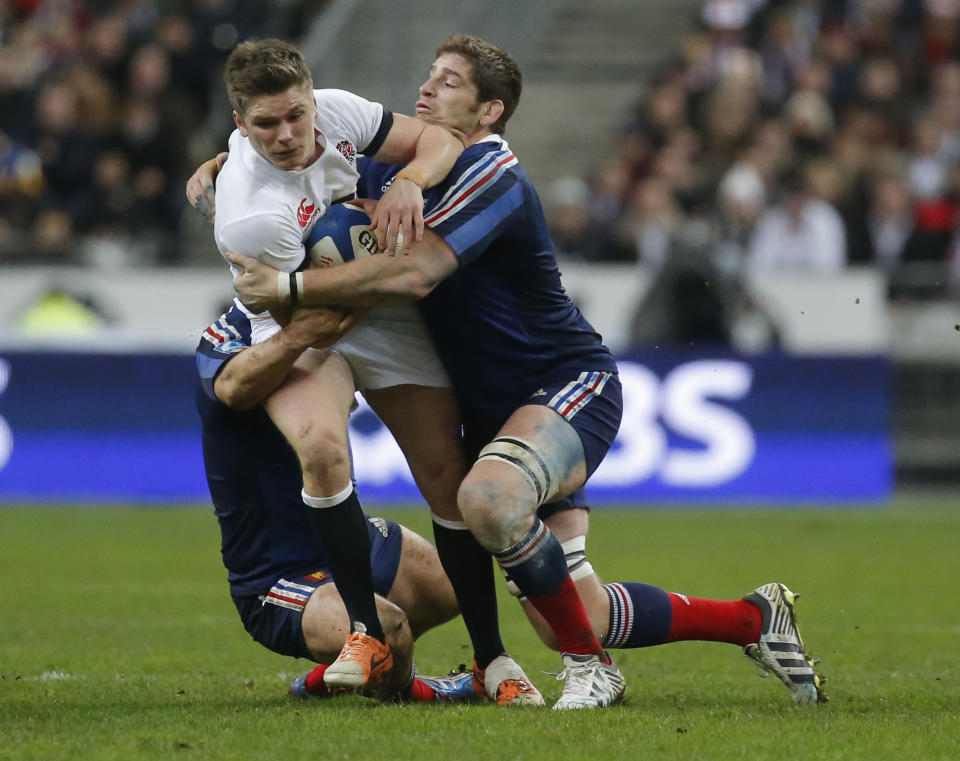 England's Owen Farrell , center, is tackled by France's Nicolas Mas, left, and Pascale Pape during their Six Nations international rugby union match between France and England at Stade de France stadium in Saint Denis, near Paris, Saturday, Feb. 1, 2014. (AP Photo/Michel Euler)
