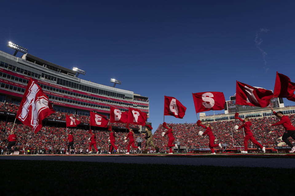 Nebraska cheerleaders celebrate a touchdown against Minnesota during the first half of an NCAA college football game Saturday, Nov. 5, 2022, in Lincoln, Neb. College athletic programs are reacting to soaring inflation the same way as everyone else — they’re looking for ways big and small to save money. (AP Photo/Rebecca S. Gratz)