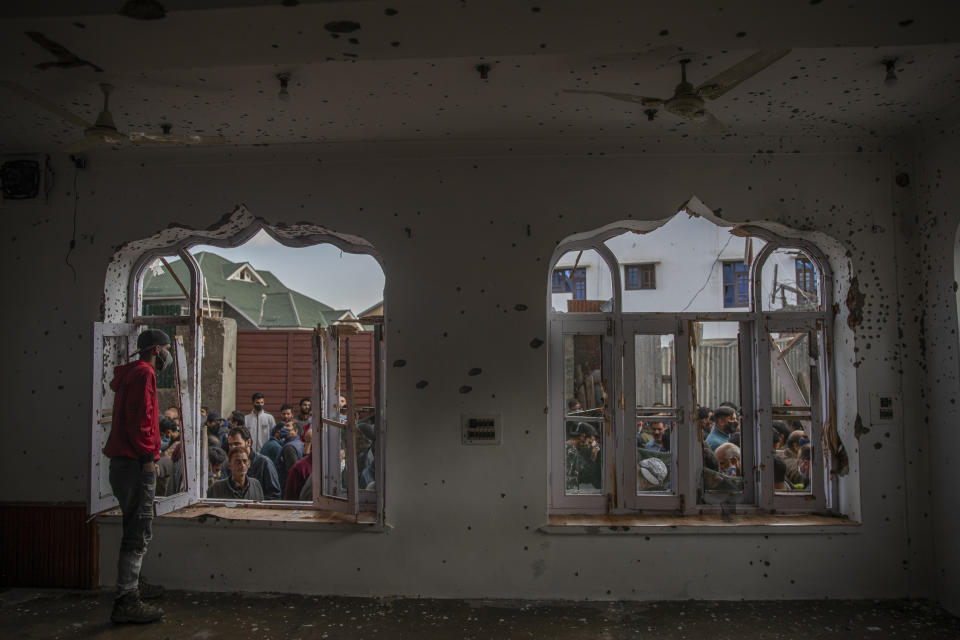 Kashmiri villagers inspect a mosque partially damaged during a gunbattle in Shopian, south of Srinagar, Indian controlled Kashmir, Friday, April 9, 2021. Seven suspected militants were killed and four soldiers wounded in two separate gunfights in Indian-controlled Kashmir, officials said Friday, triggering anti-India protests and clashes in the disputed region. (AP Photo/ Dar Yasin)